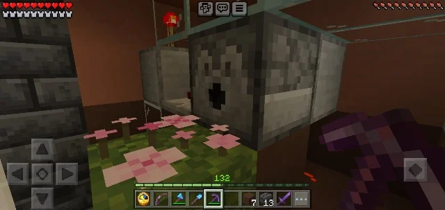 Dispenser facing pink petals on a grass block in a mobile survival world