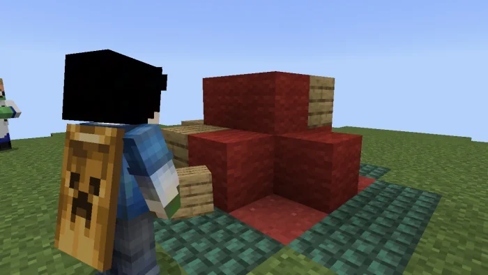 A player building a wood and red wool treasure defense