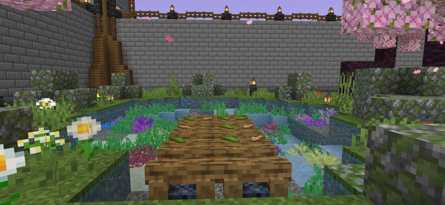 Short wooden crossing over a planted pond beside a stone wall