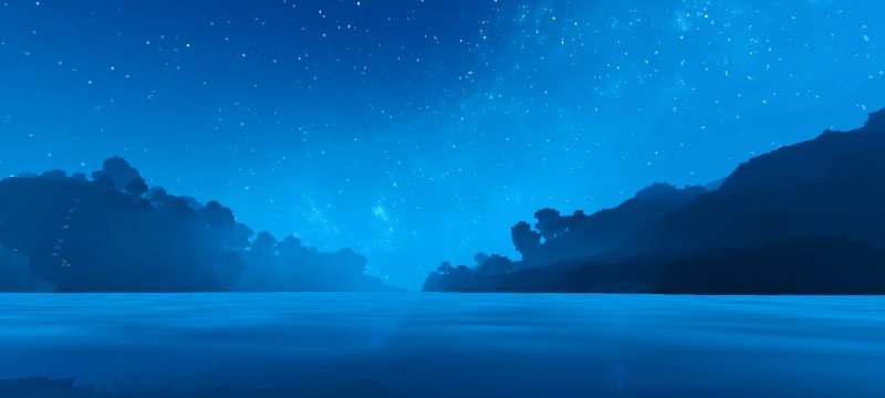 Misty blue night sky above water between distant dark shores