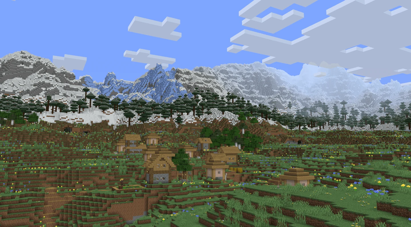 A village below a broad snow-covered Tectonic mountain range