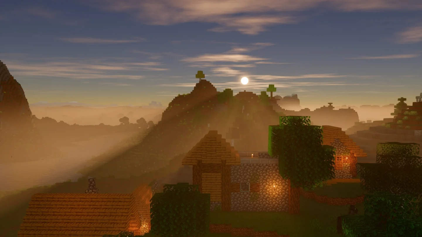 Glimmer village at low sun with warm light and fog between hills