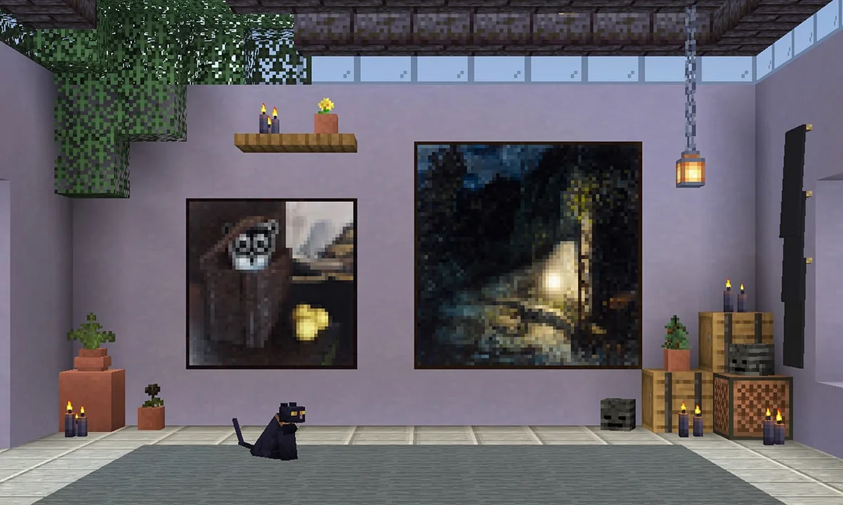 A cat sits in a decorated room with two of the new paintings
