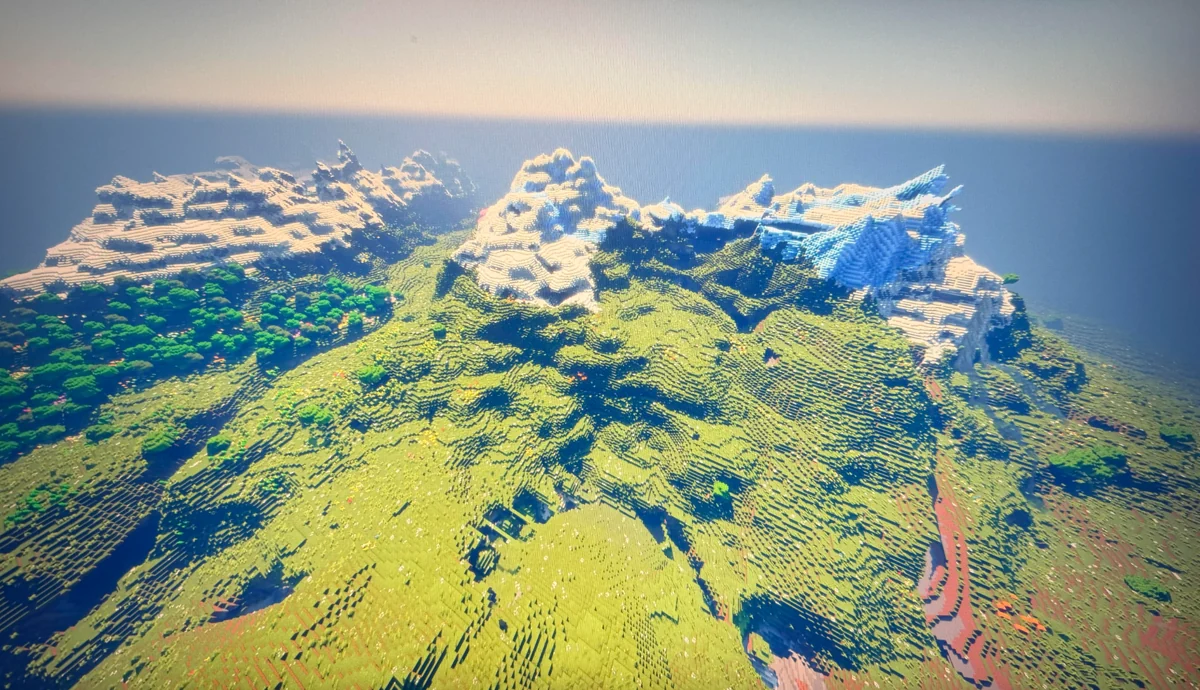 Original player image of the seed showing a green mountain clearing, forest edge and snowy ridges