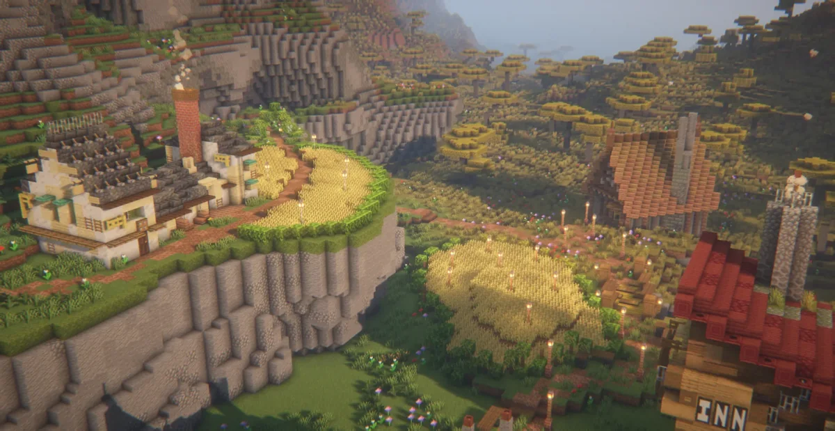 Elevated medieval houses beside cliffs and farmland in Minecraft Town