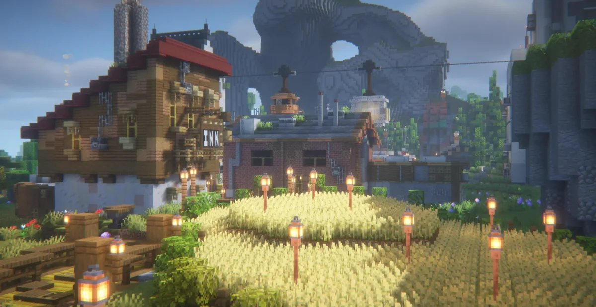 Lantern-lit crop fields and houses with the rocky skyline behind them